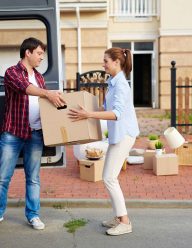 portrait-of-man-taking-cardboard-boxes-out-of-moving-van-and-passing-them-to-his-wife--SBI-324310479 (1)