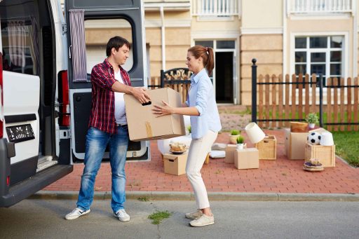 portrait-of-man-taking-cardboard-boxes-out-of-moving-van-and-passing-them-to-his-wife--SBI-324310479 (1)