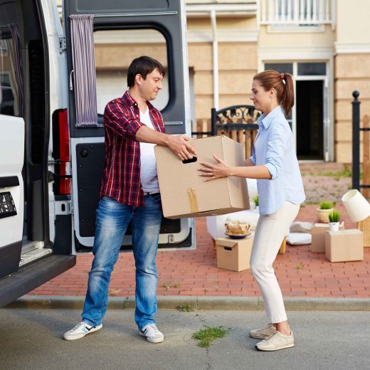 portrait-of-man-taking-cardboard-boxes-out-of-moving-van-and-passing-them-to-his-wife--SBI-324310479 (1)